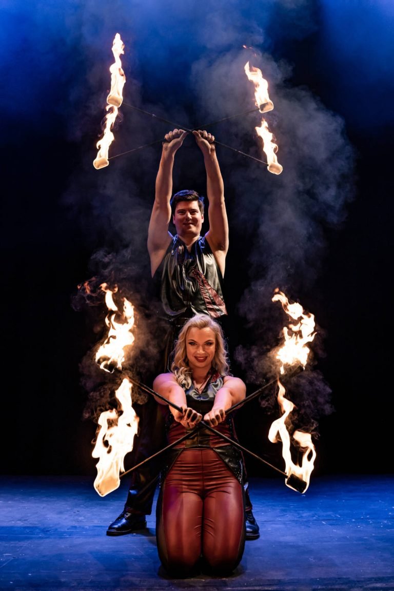 Two fire dancers with flaming sticks